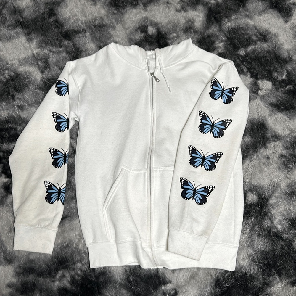 White zip up hoodie with blue butterfly’s on the sleeves